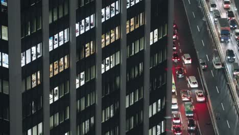 office building next to a highway with heavy traffic at night in shibuya, tokyo city, japan