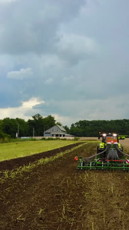 tractor preparing land. farmer in tractor preparing land with seedbed cultivator vertical video