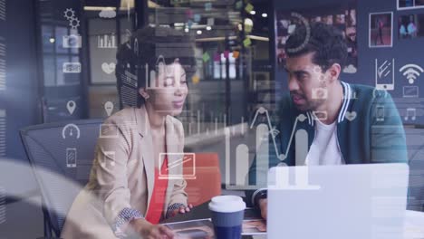 Animation-of-statistical-data-processing-over-diverse-man-and-woman-discussing-over-laptop-at-office