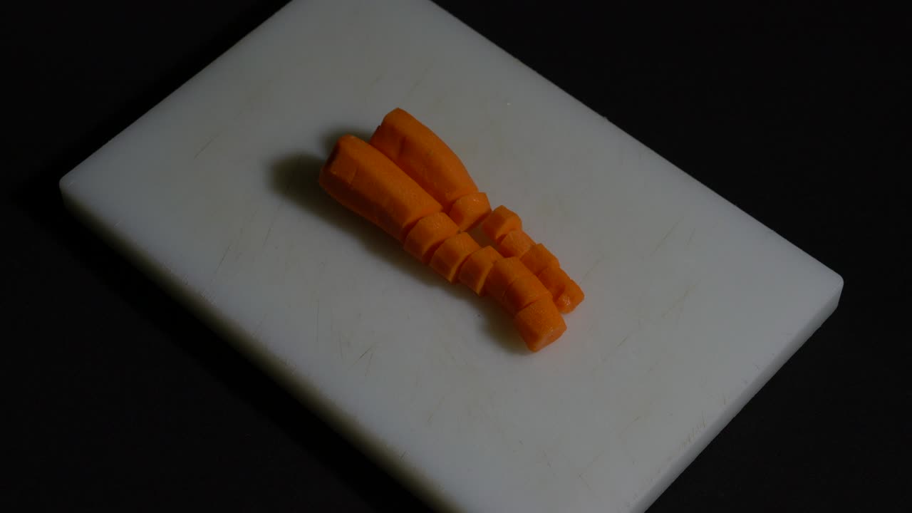 cortando zanahorias en la tabla de la cocina