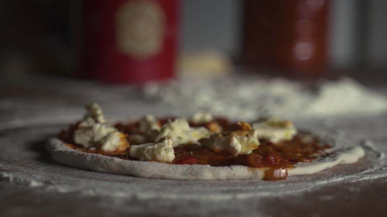 4K Raw home made pizza with cheese, tomato sauce and flour on wooden table rack focus