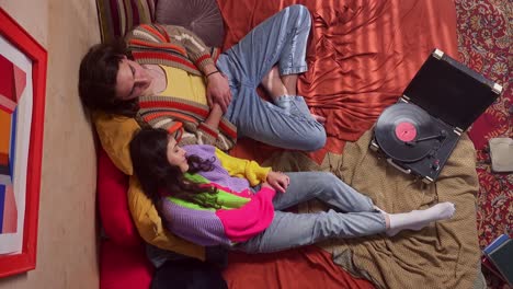 couple relaxing on bed with record player