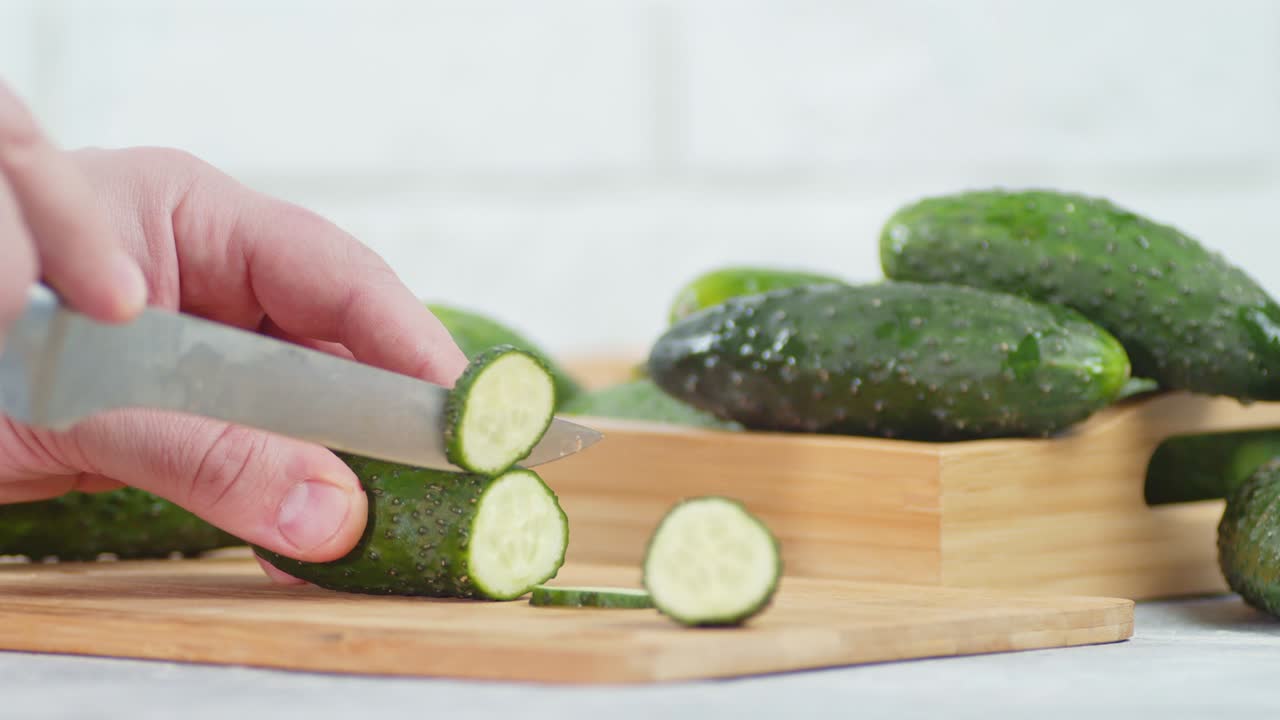 남자 손이 절단판에 칼로 호박을 잘라내고 있습니다.