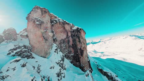 Filmische-FPV-Kletteraufnahme-Und-Abtauchen-Im-Felsigen-Gelände-Eines-Schneebedeckten-Berges