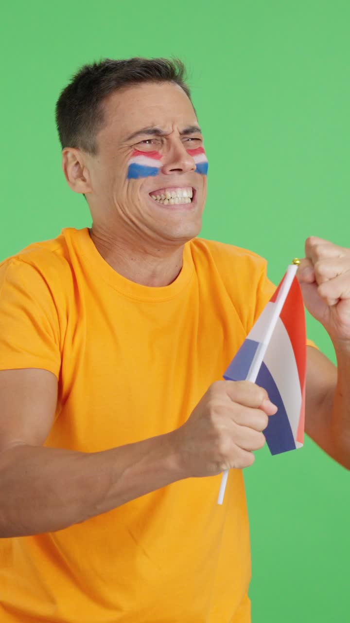 Nervous man cheering for Holland during a match looking away