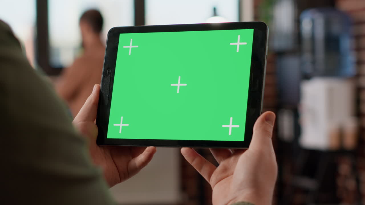 Startup manager looking at horizontal greenscreen on digital tablet