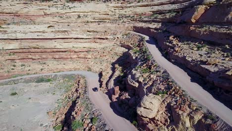 Antena-Como-Un-Coche-Viaja-Por-La-Peligrosa-Carretera-De-Montaña-De-Moki-Dugway-Desierto-De-Nuevo-México-Suroeste-4