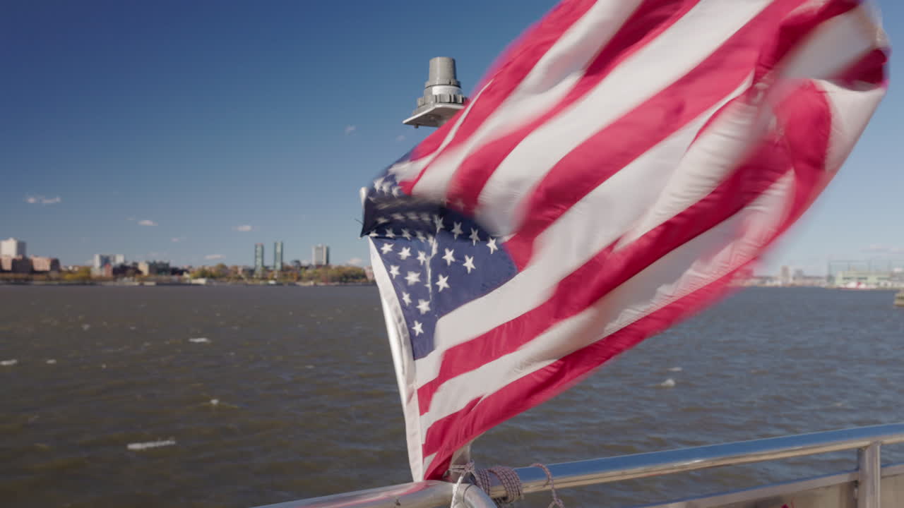 Bandiera americana che sventola su un battello turistico nel porto di New York, vista panoramica sul fiume durante la gita alla Statua della Libertà, USA