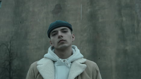 Portrait-of-Trendy-Young-Man-against-Old-Concrete-Building