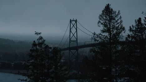 view of lions gate bridge in vancouver from prospect point lookout on a rainy day and moody atmosphere during winter, british columbia, canada