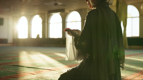 a muslim woman praying in a mosque