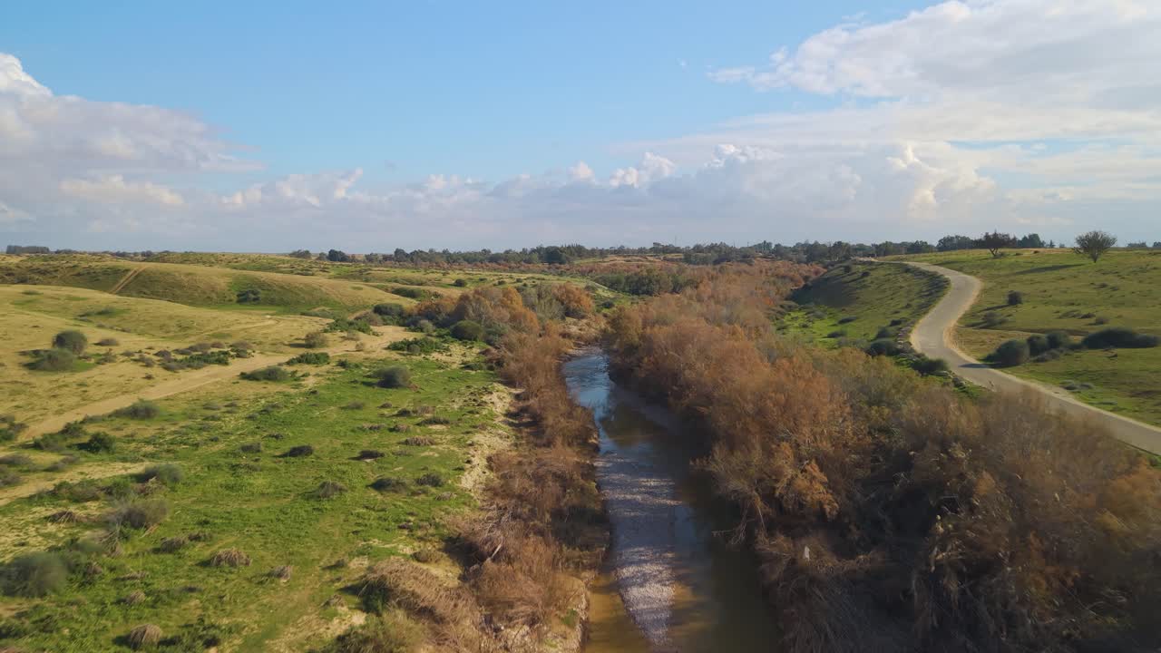 La vegetazione lussureggiante e l'erba verde ricoprono il paesaggio intorno al ponte di corda di Besor durante la trasformazione invernale