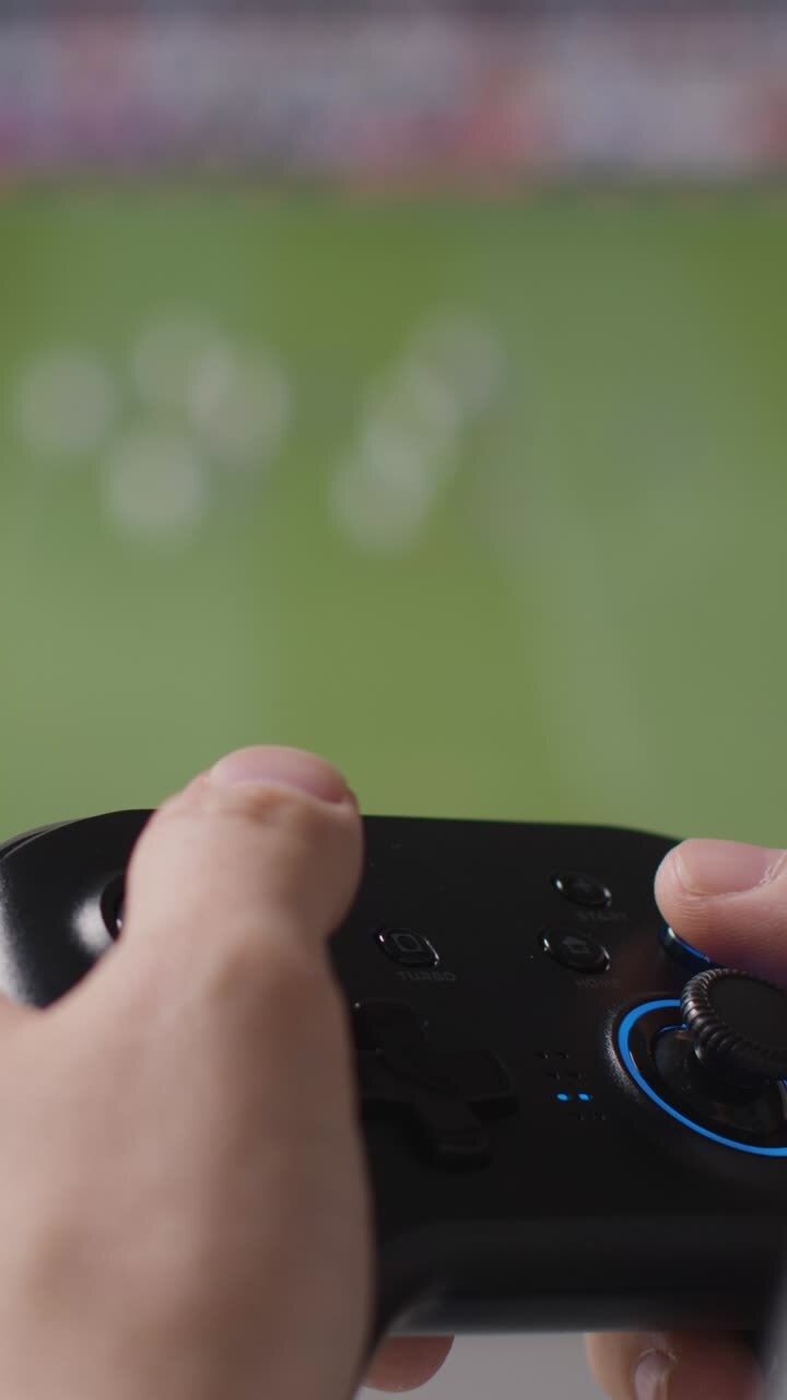 video vertical de cerca manos hombre jugando deportes pantalla del controlador de videojuegos