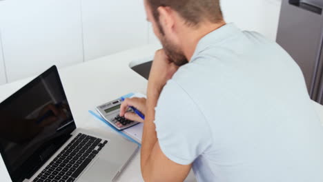 hombre molesto haciendo su contabilidad con una computadora portátil