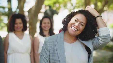 medium shot of smiling bridesmaid touching hair and looking at the camera