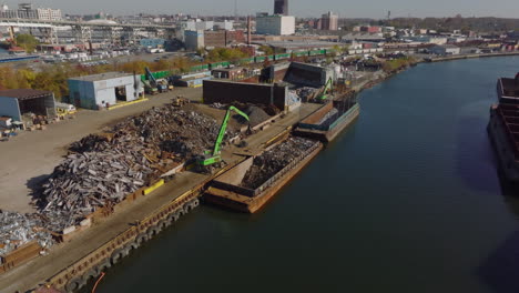 Aerial-view-of-machinery-loading-metal-scrap-on-cargo-boat.-Industrial-borough-in-city.-Recycle-and-ecology-concept.-New-York-City,-USA