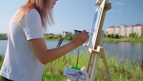 woman painting outdoors by a lake