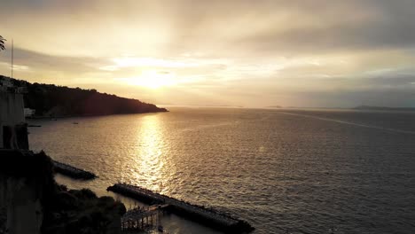 Drone-flying-up-filming-sunset-with-hill-in-the-background