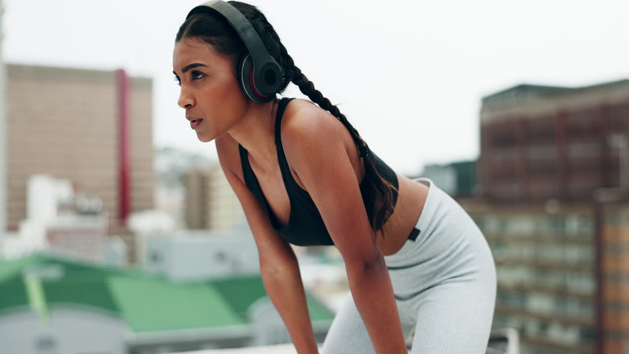 Donna, cuffie e fitness sul tetto per una pausa
