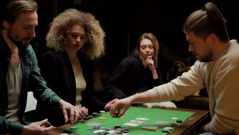 grupo de amigos jugando al póquer sentados en sillas en una mesa 1