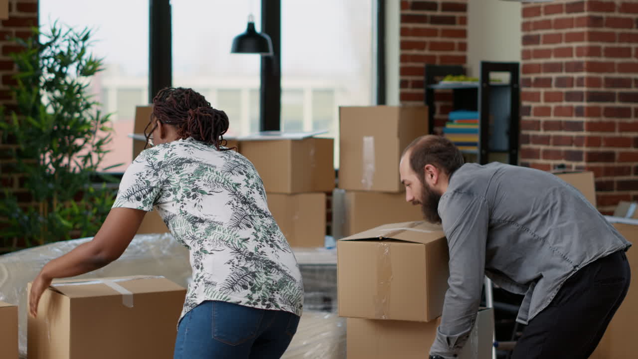 Life partners carrying boxes of furniture to move in new real estate household