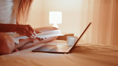 mujer trabajando en la computadora portátil en la cama por la noche