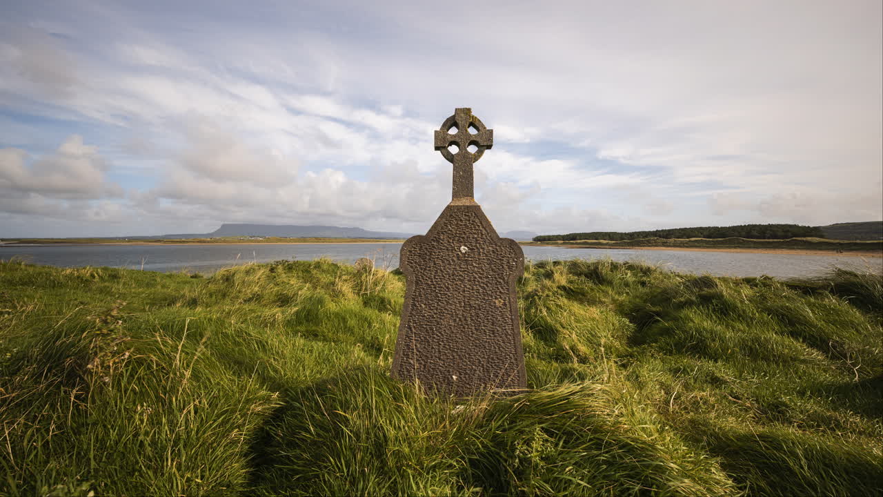 lapso de tiempo en movimiento del cementerio histórico en la costa de irlanda con colinas en la distancia y nubes en movimiento en el cielo