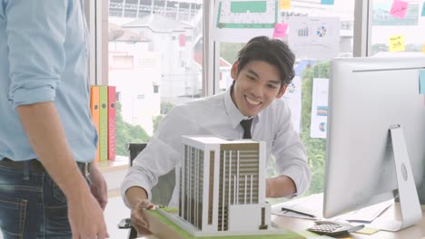 two business partner shake hands when meeting. engineers team working. male architect and colleague constructing an architectural model