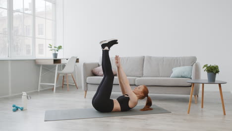 mujer haciendo levantamientos de piernas en casa