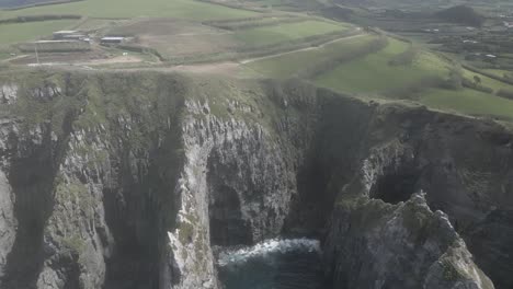 avión no tripulado volando sobre los acantilados rocosos de ponta do cintrao de la isla de sao miguel, azores, portugal