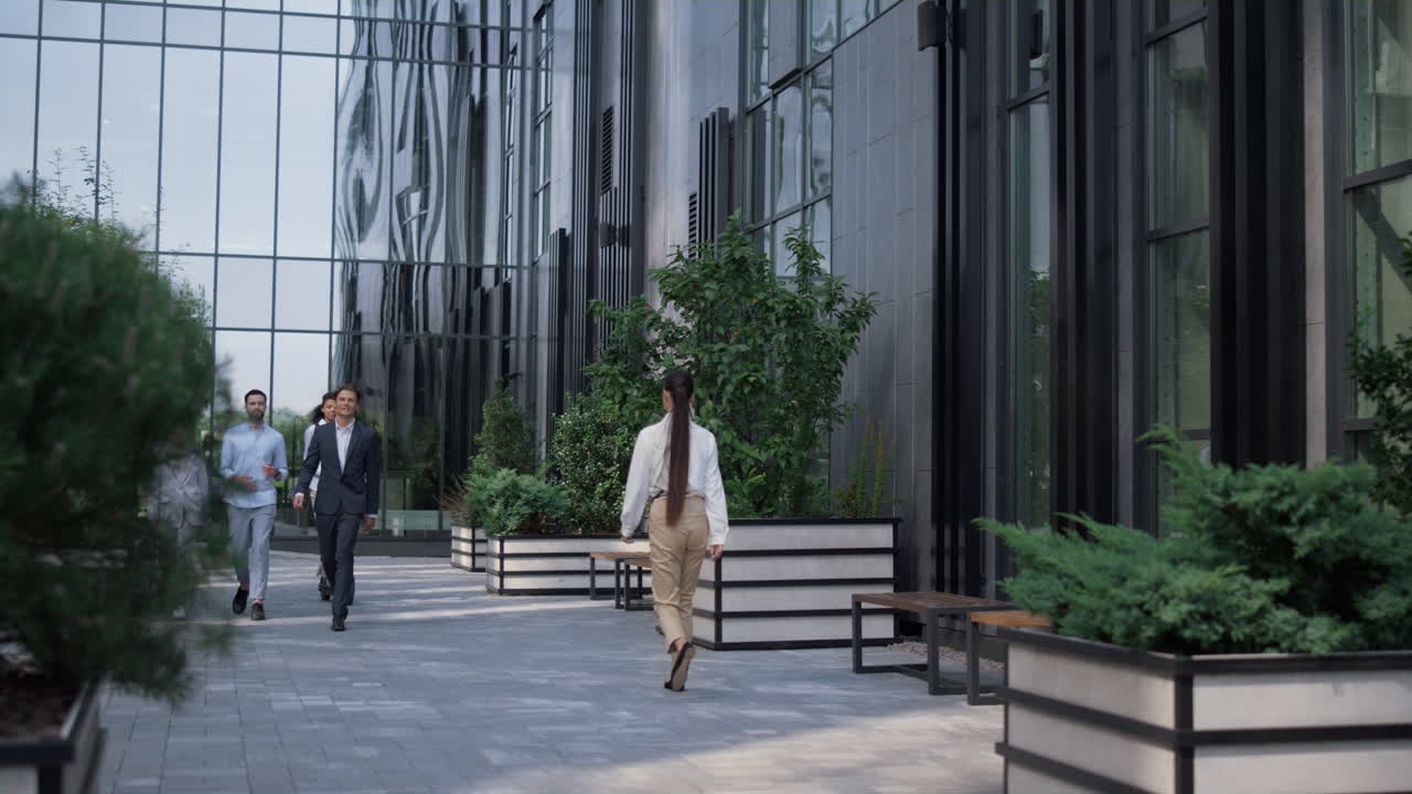 una donna d'affari sorridente su uno scooter elettrico che torna a casa nel centro.