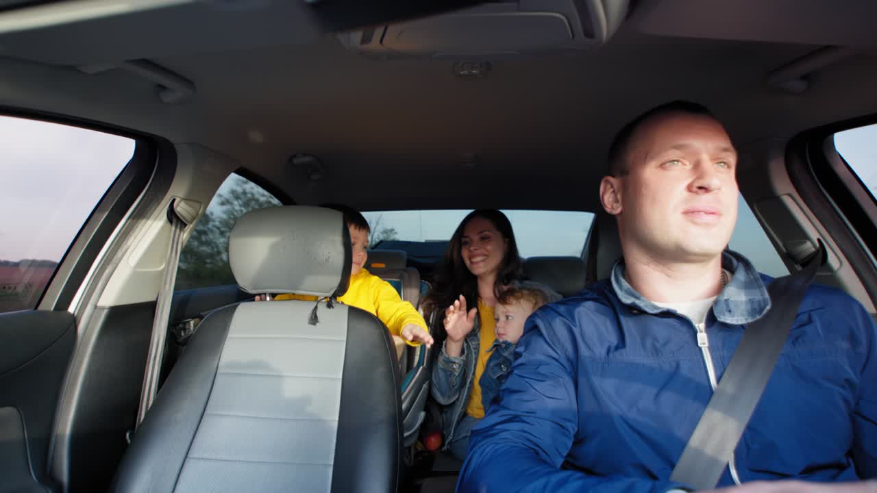 familia alegre con niños varones jóvenes divirtiéndose en el coche en un paseo compartido en el tren de fin de semana fuera de la ciudad