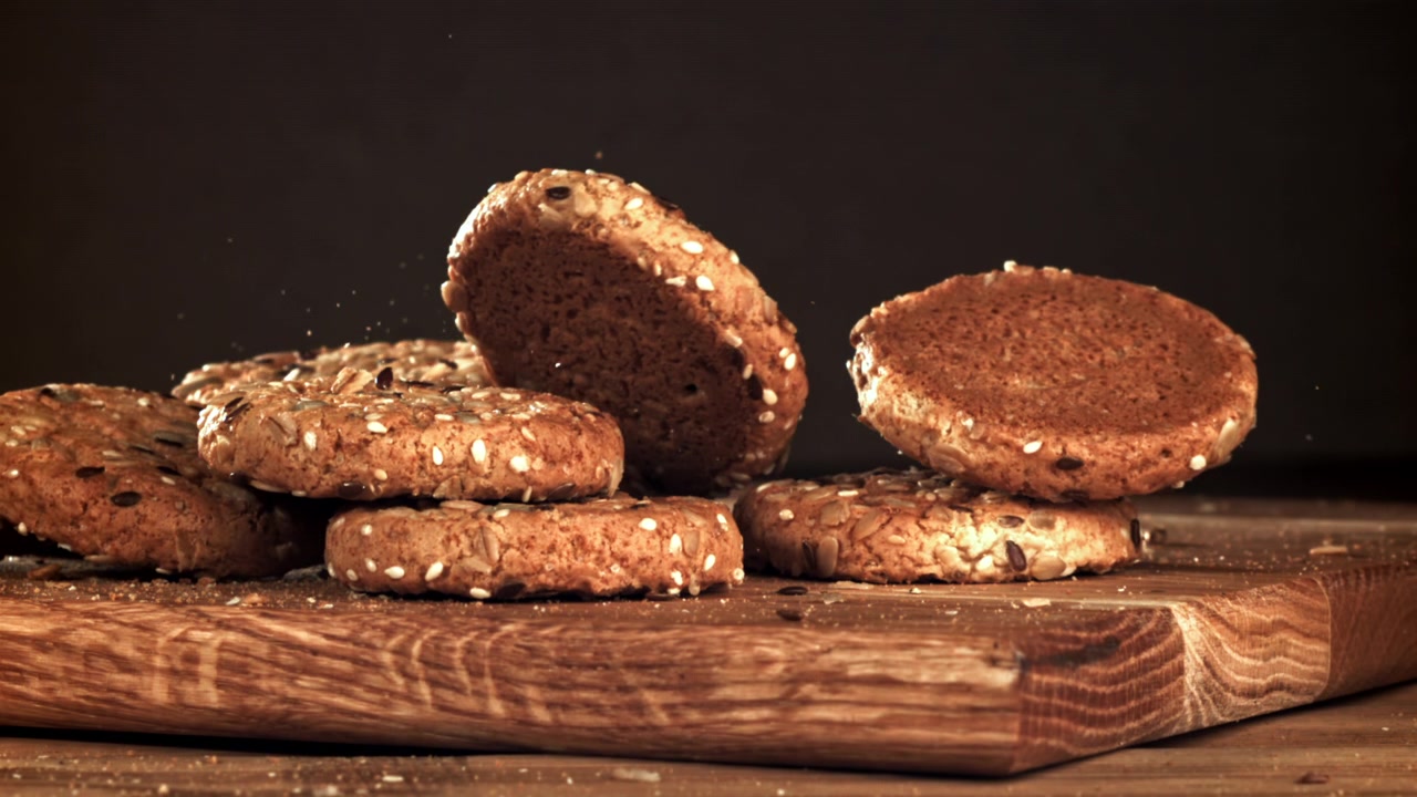 Slow Motion of Seed Cookies Falling onto a Wooden Board