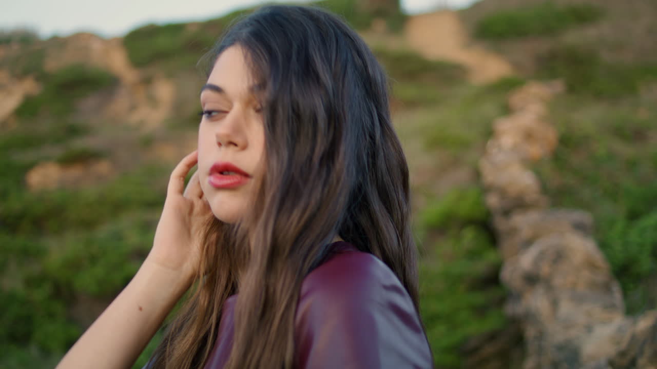 retrato de una joven morena en frente de la colina verde. una mujer posando un clima sombrío.