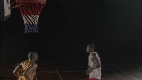 three men play basketball on an indoor court 6