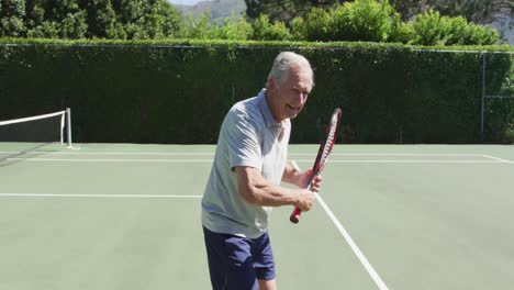 Caucasian-senior-man-with-racket-shadow-practicing-tennis-on-the-tennis-court