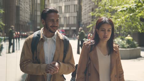 muslim couple on date talking as they walk along city street together 2