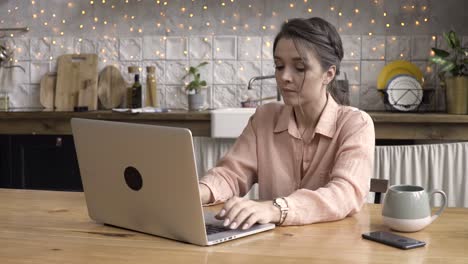 woman working from home on laptop in kitchen