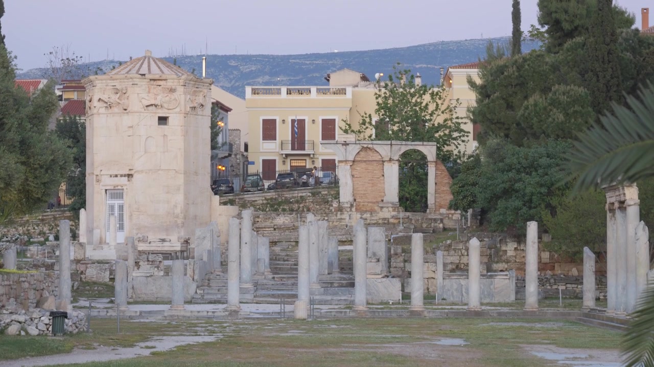 Marmorsøjler fra den romerske Agora med Vindtårnet i skumringen i Athen, Grækenland