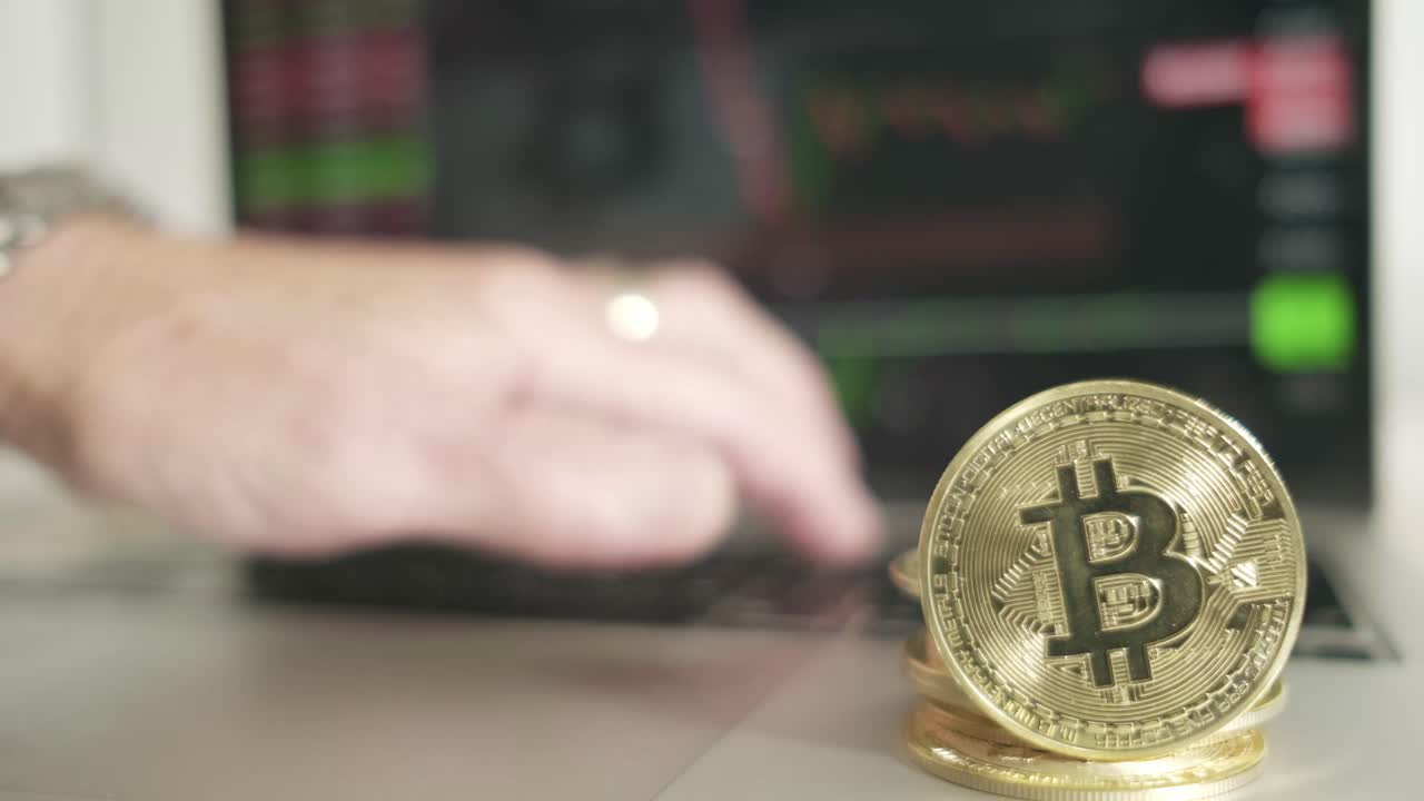 moneda de oro de bitcoin con portátil y gráfico del mercado de valores en el fondo comercio de mano caucásico en línea, criptomoneda y concepto de inversión