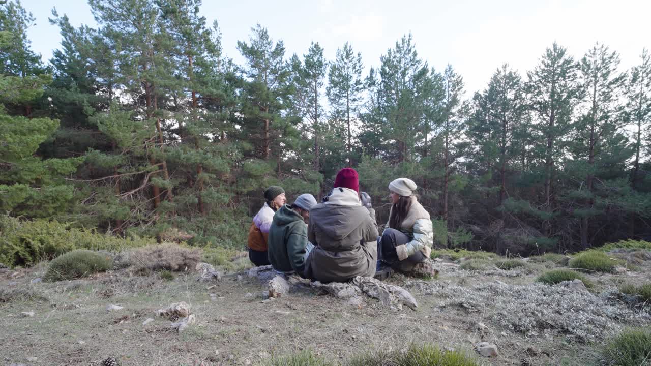 Group of friends sitting and talking in a forest