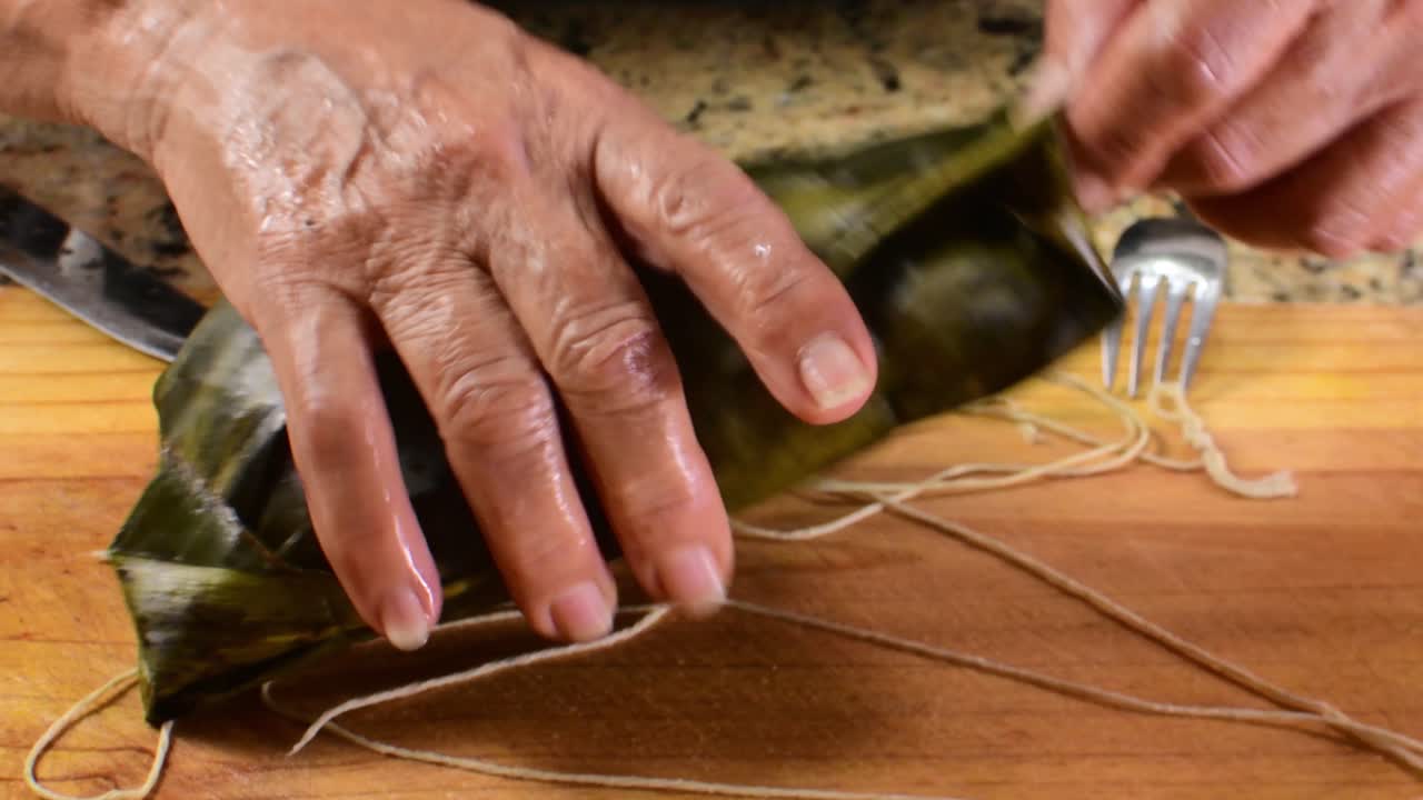 Authentic close-up showing the full process of unwrapping the banana leaf from a Hallaca, perfectly ready-to-eat for a Christmas recipe video