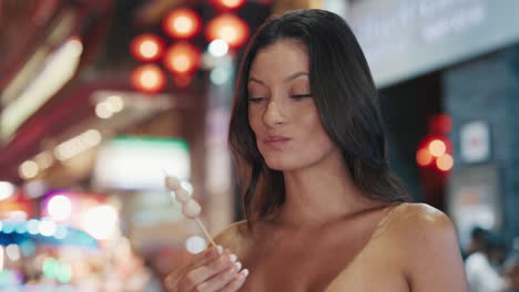 woman eating street food at night market