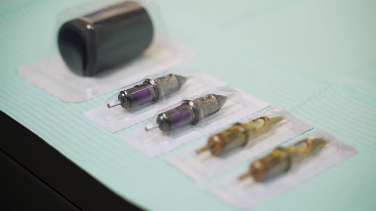 Tattoo sterilized needles in packaging prepared on tattoo artist table