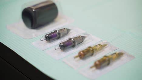 tattoo sterilized needles in packaging prepared on tattoo artist table