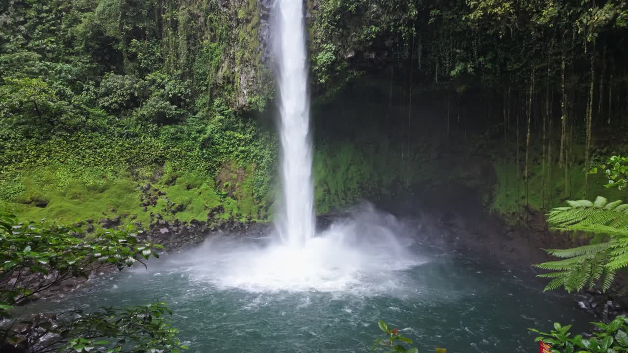 Scenic slow-motion view of the Fortuna Waterfall with breathtaking tropical greenery around in Costa Rica