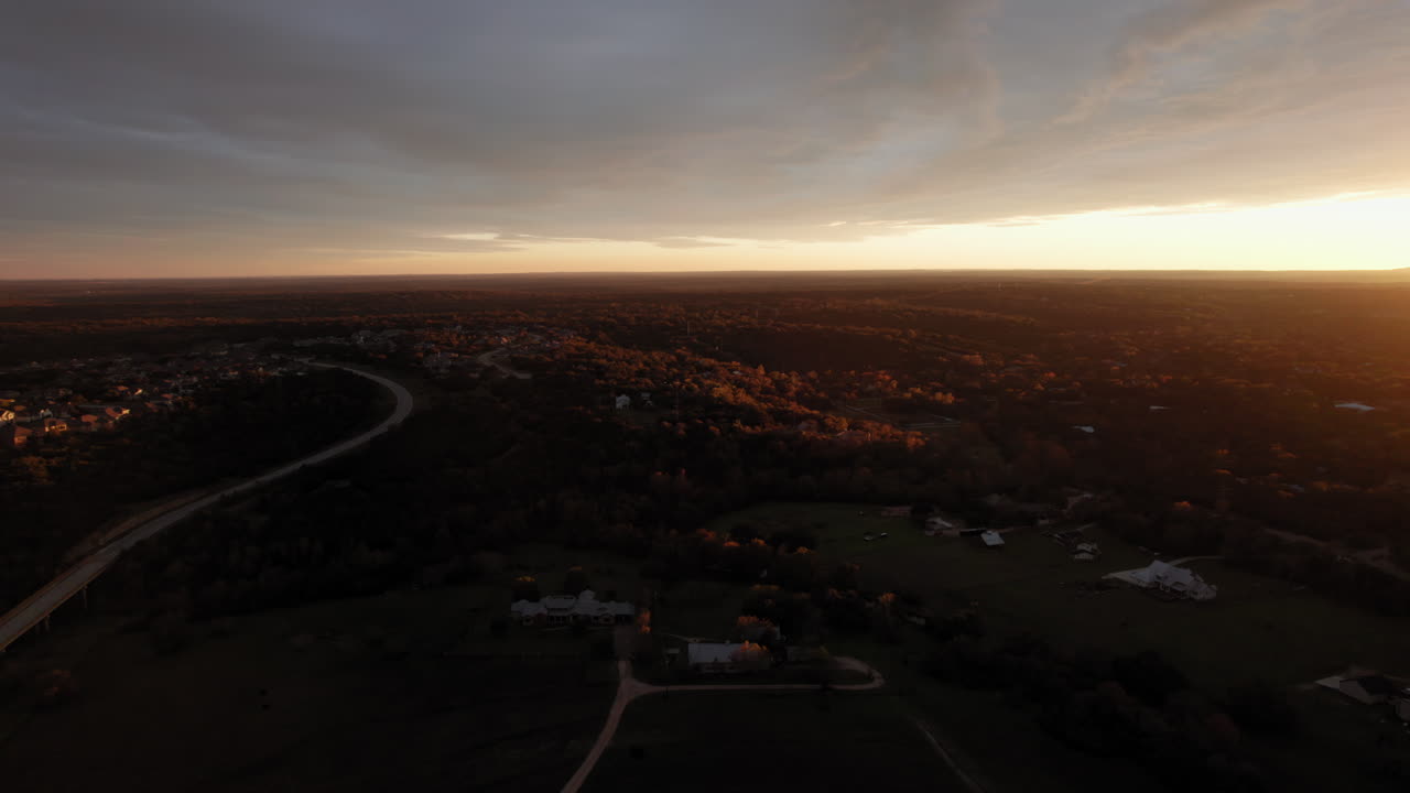 fotografía aérea de una puesta de sol en la hora dorada sobre el paisaje suburbano, dolly hacia adelante