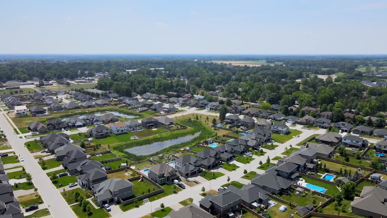 Drone flyr bort fra en forstad i Mount Brydges på en solrik dag