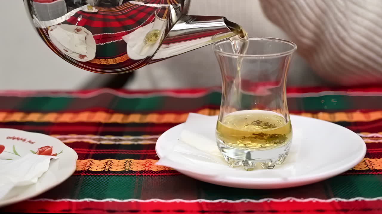 Close up of a woman pouring tea in a Turkish tea cup at a restaurant