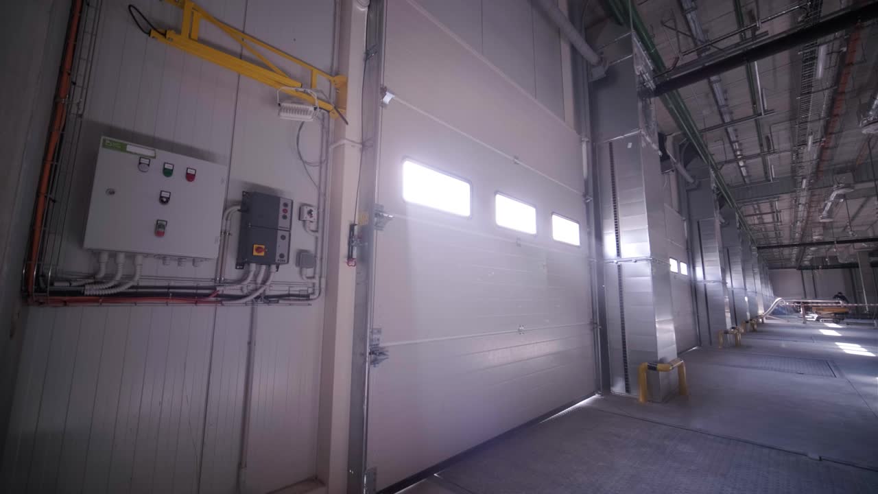 proceso de construcción de un gran almacén moderno con múltiples puertas de garaje para un fácil acceso y transporte de mercancías.